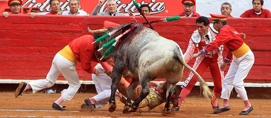 Momento en el que el primer toro arremete contra Karla de los Ángeles y los monosabios. EFE