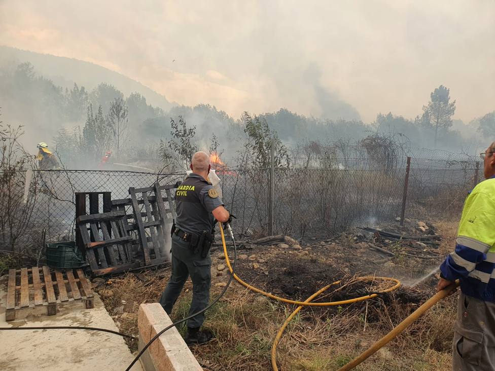 Un guardia civil colabora en los trabajos de extinción ante la proximidad del fuego a las casas