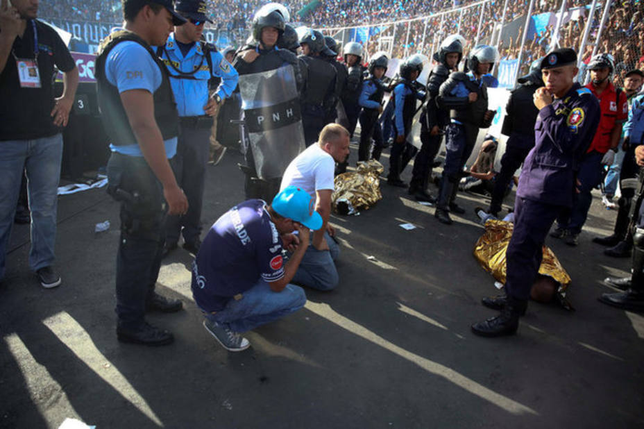 Men react next to two dead bodies after an stampede at the National Stadium in Tegucigalpa, Honduras