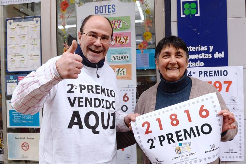 Los propietarios de la papelería “Julcar” de Valladolid, muestran el número 21816, segundo premio de la loterí