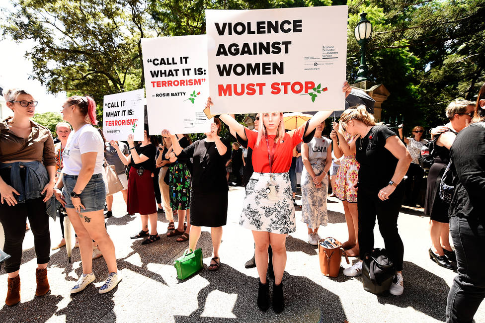 Protesters hold placards during a domestic violence protest organised by The Red Rose Foundation in Brisbane, Friday, February 21, 2020. (AAP Image/Albert Perez) NO ARCHIVING