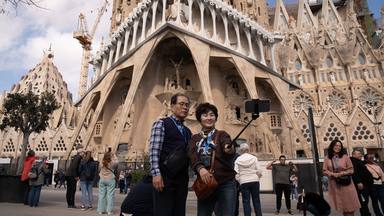 Varios turistas se hacen fotos junto a la Sagrada Familia en Barcelona