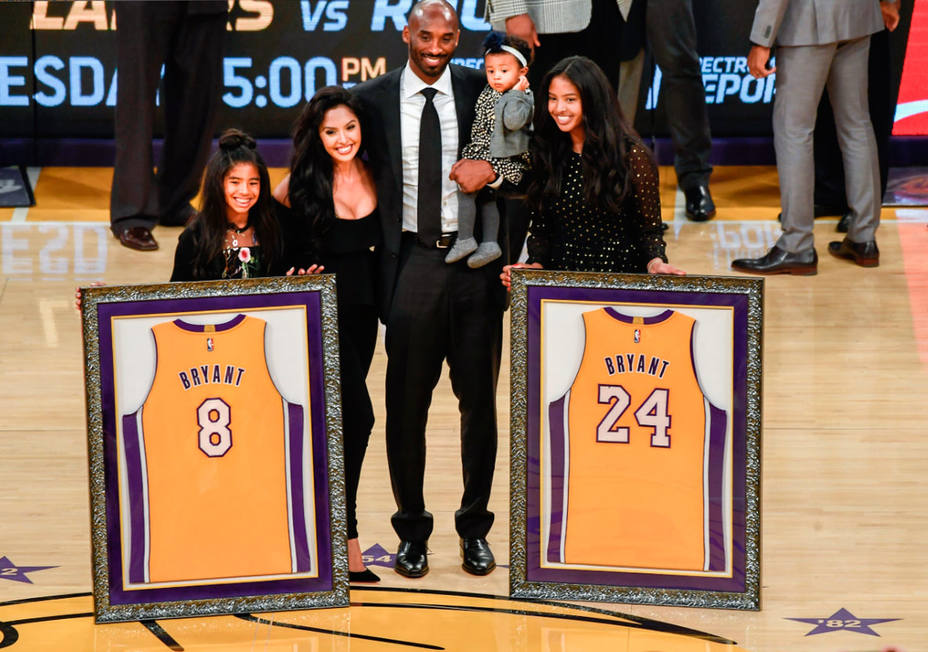 Kobe Bryant, junto a su familia y los dos dorsales inmortalizados en el Staples Center. REUTERS