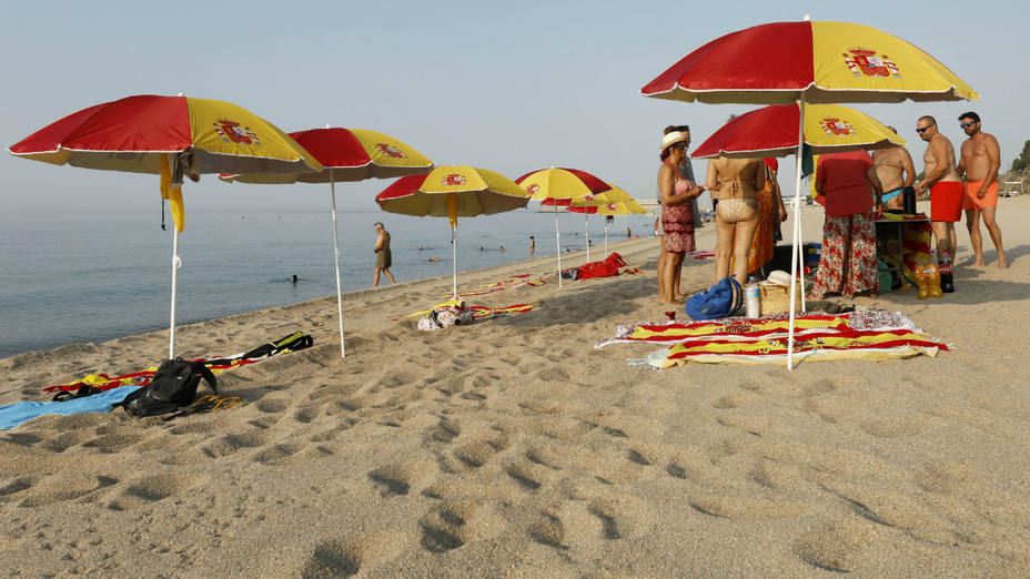 Sombrillas y toallas con la bandera de España en la playa catalana de Arenys de Mar