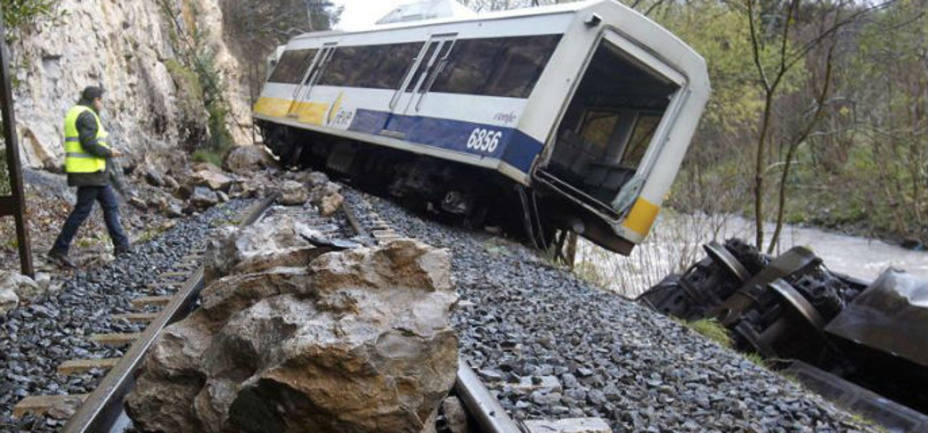 Una roca sobre la via en las inmediaciones del tren de pasajeros que ha descarrilado en la localidad cántabra de Golbarzo. EFE