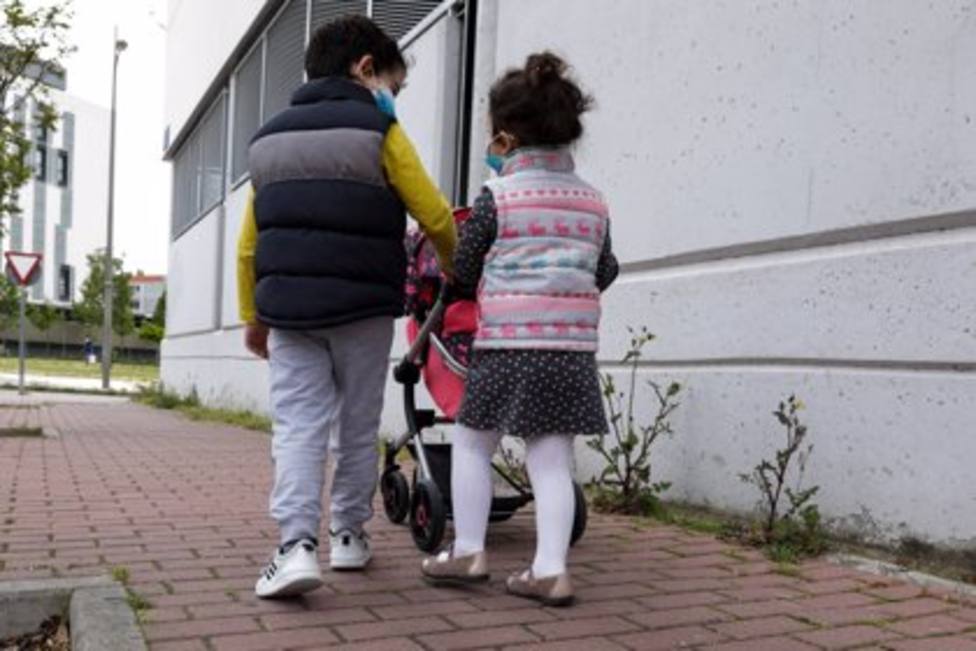 Dos niños paseando por la calle con mascarillas - JESÚS HELLÍN - EUROPA PRESS