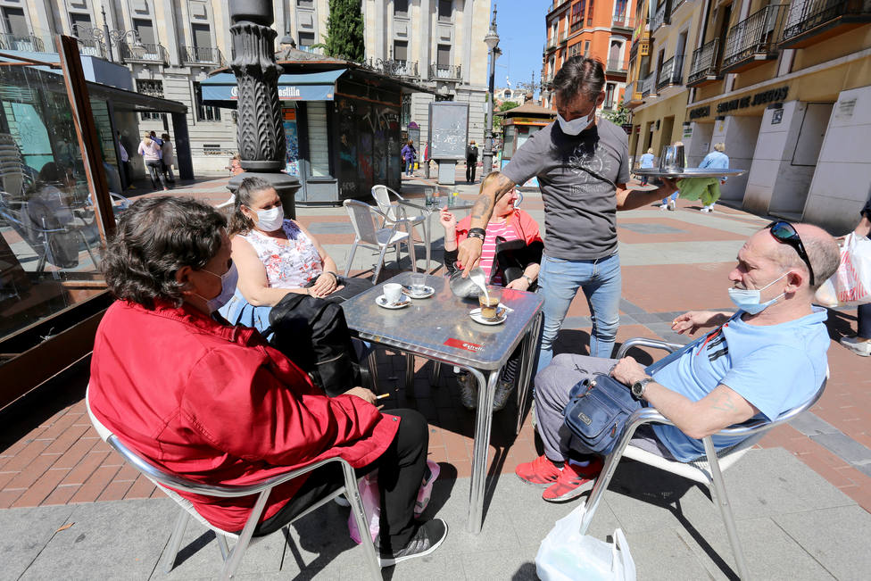 Un hostelero atiende a un grupo de clientes en su terraza, en Valladolid