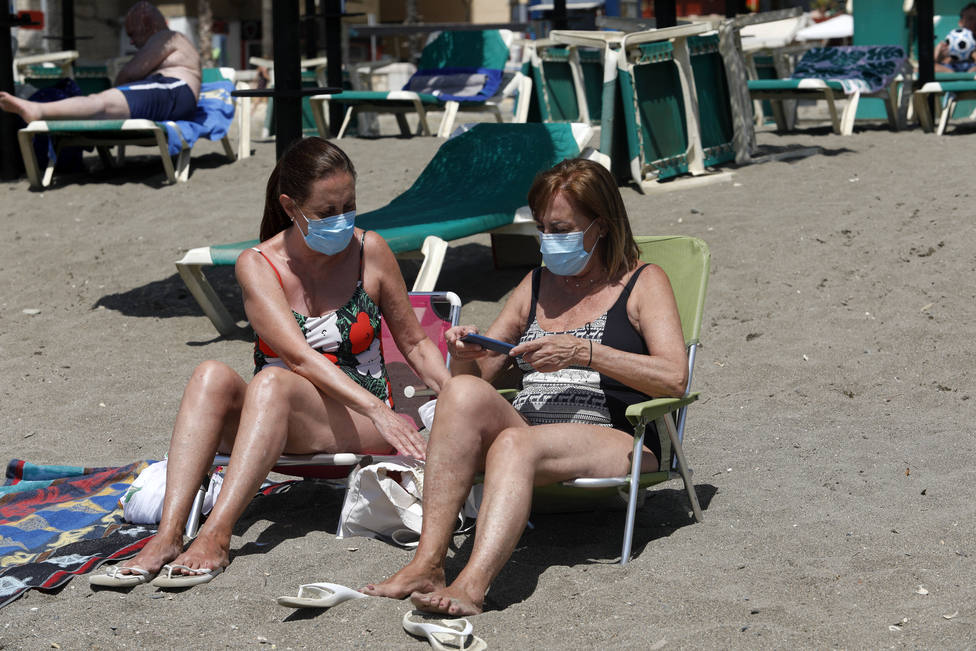Foto de archivo de dos mujeres en la playa con mascarilla - FOTO: Europa Press / Alex Zea