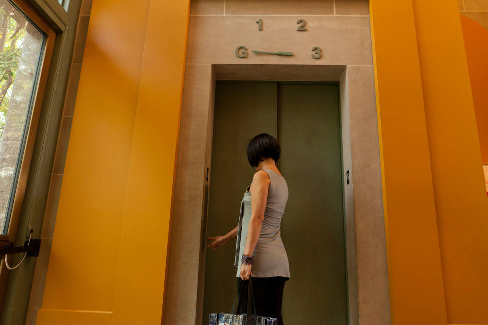 Mujer llamando al ascensor