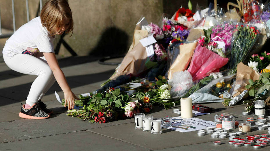 A girl leaves flowers for the victims of an attack on concert goers at Manchester Arena, in central Manchester