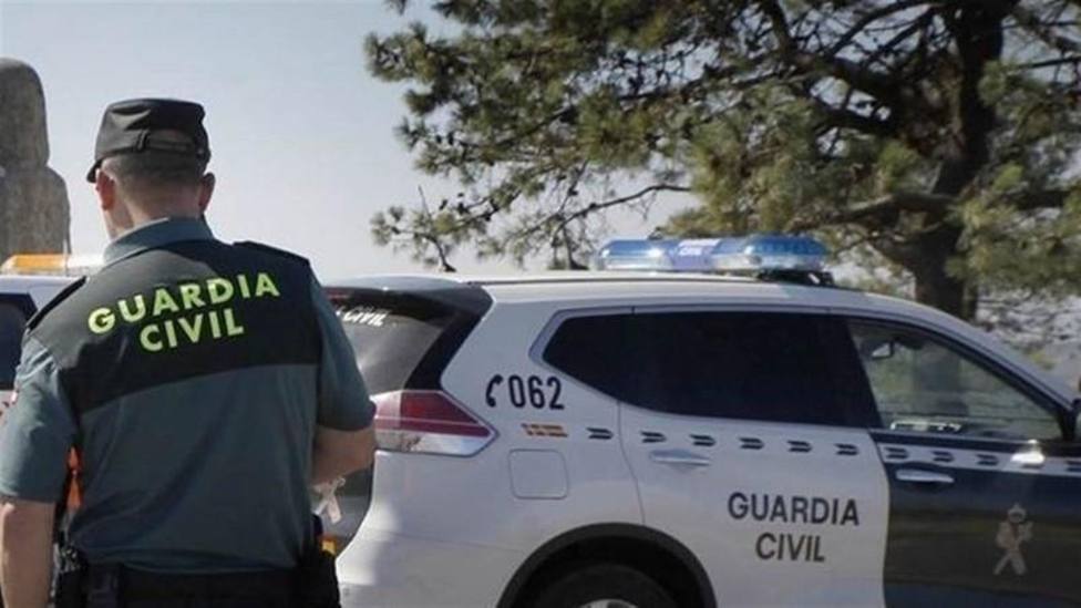 Foto agente de la Guardia Civil y vehículo policial