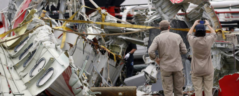 Operarios buscan pistas entre los restos del avión de AirAsia.Reuters