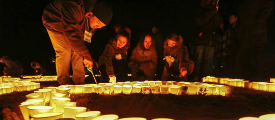 Un grupo de personas enciende velas durante una ceremonia en memoria a las víctimas del terremoto y tsunami. EFE