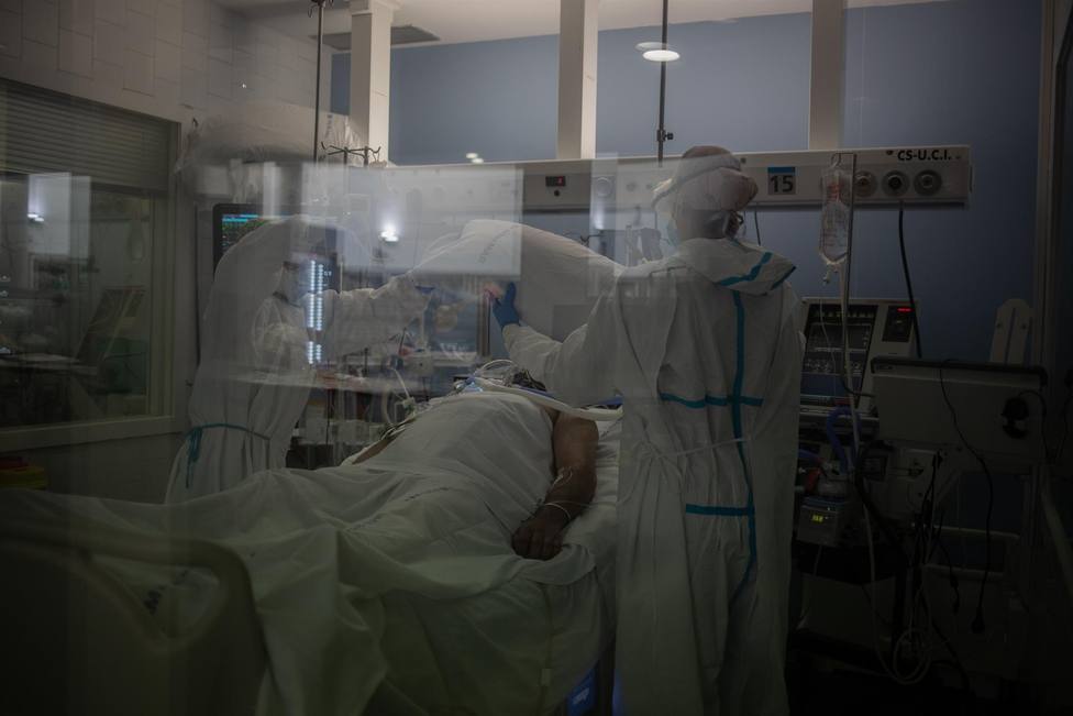 Trabajadores sanitarios protegidos atienden a un paciente en la UCI - David Zorrakino - Europa Press - Archivo