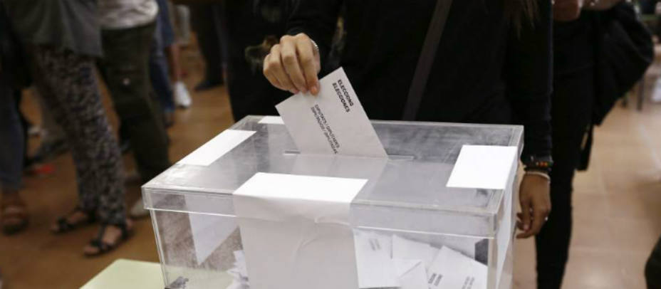 Persona depositando su voto en una urna de un colegio electoral. EFE
