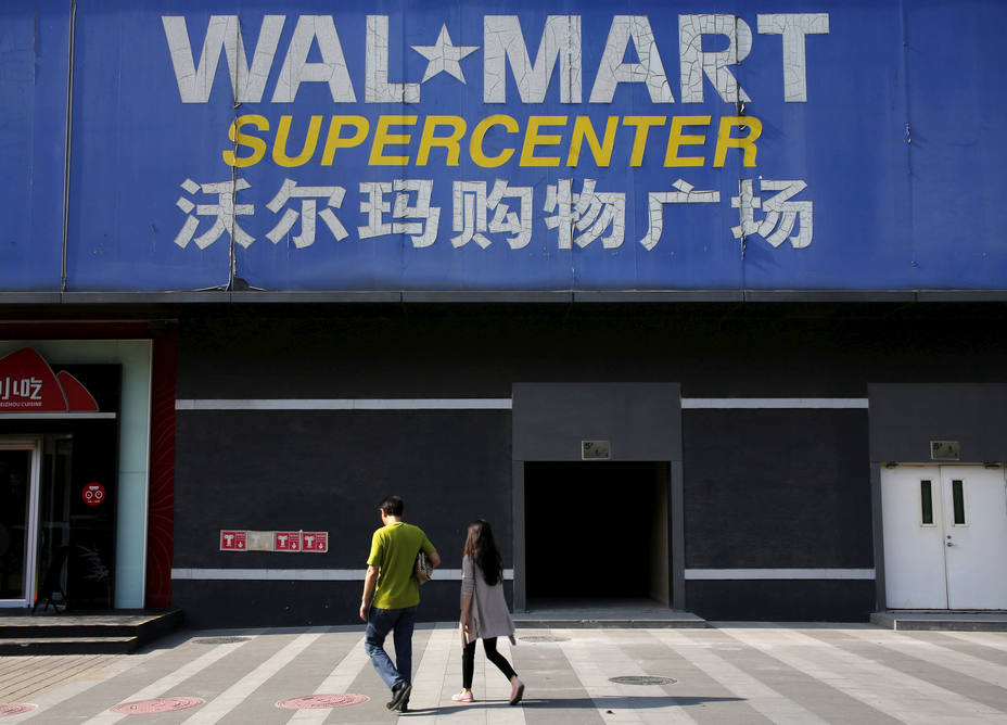 Peatones caminan más allá de un letrero de Wal-Mart en su sucursal en Beijing, China