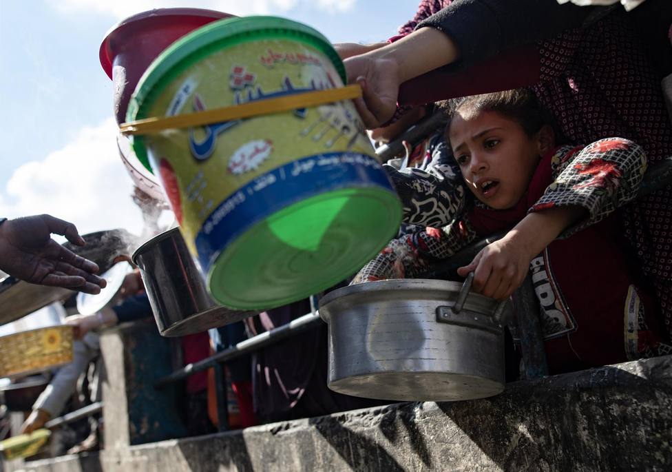 Displaced Paletsinians line up for food aid in Rafah