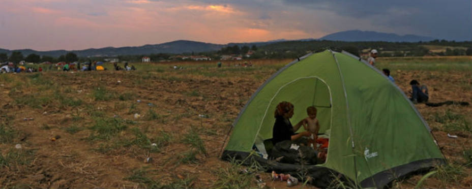 Familias de refugiados sirios intentan atravesar la frontera que divide Grecia y Macedonia. Reuters