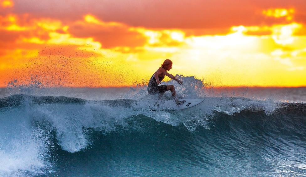 Un surfista aprovechando los últimos rayos de sol