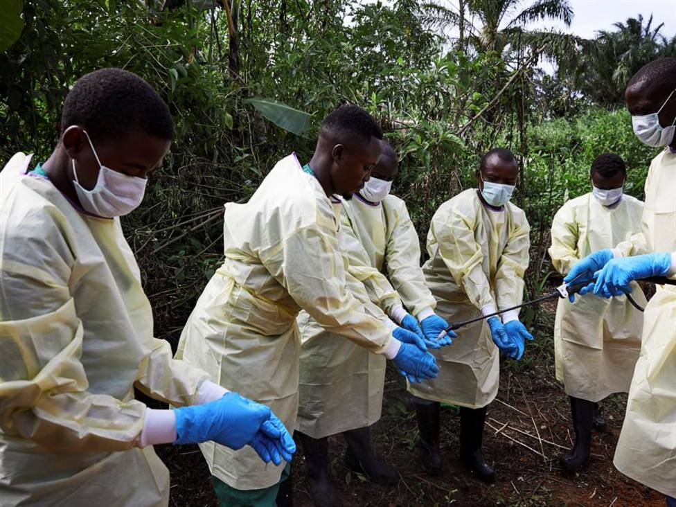 Trabajadores sanitarios se desinfectan tras enterrar a un enfermo de ébola en la RDC en 2019