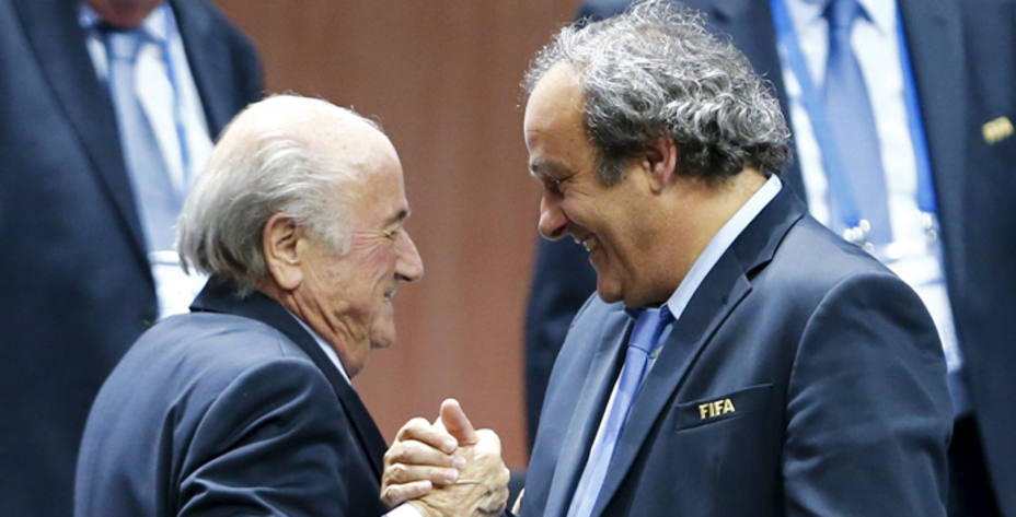 Sepp Blatter, actualmente suspendido, estrecha la mano a Michel Platini. REUTERS