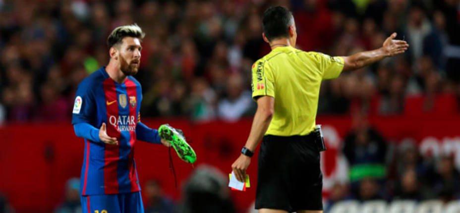 Leo Messi, tras ver la cartulina amarilla en el Sánchez Pizjuán. REUTERS