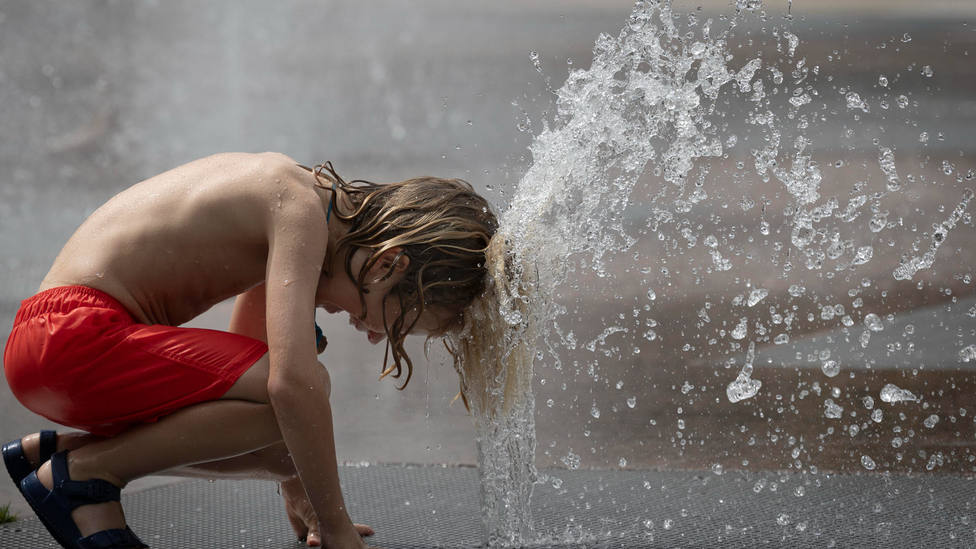 Un niño se refresca para combatir las altas temperaturas en plena ola de calor