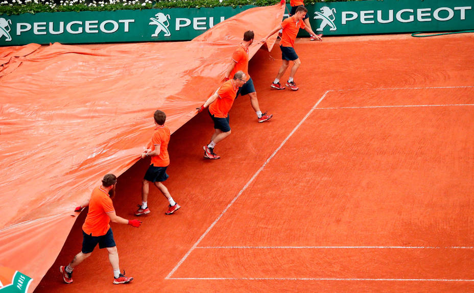 Operarios cubren la pista central de Roland Garros por la lluvia. EFE