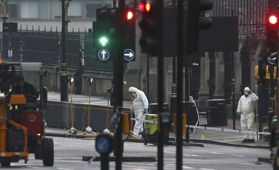 Forensics investigators and police officers work at the site near Westminster Bridge the morning after an attack by a man driving a car and weilding a knife left five people dead and dozens injured, in London