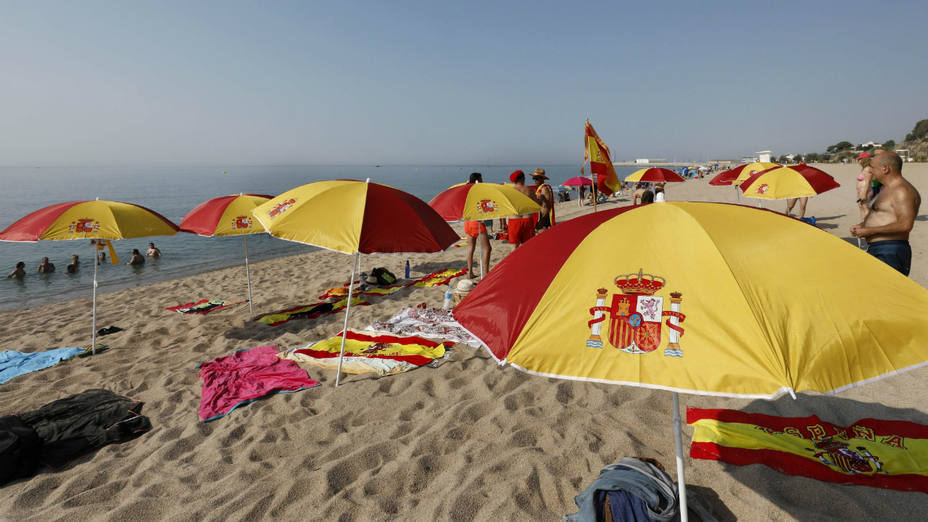 Sombrillas y toallas con la bandera de España en una playa de Cataluña