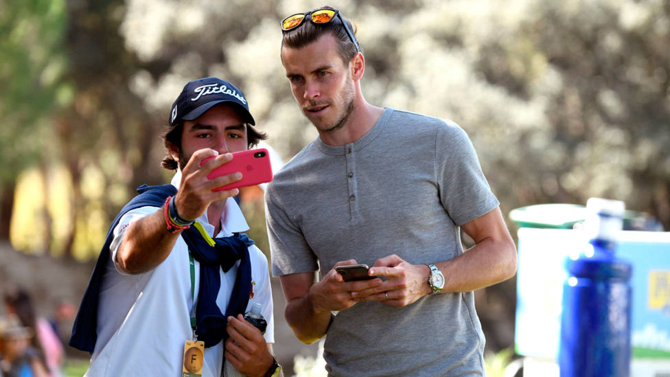 Gareth Bale se fotografía con un aficionado durante el Open de España. EFE