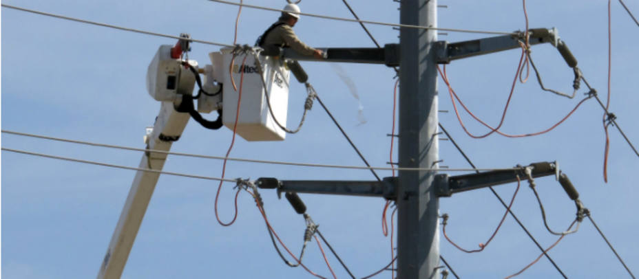 Imagen de un electricista en un poste de luz. Imagen de archivo