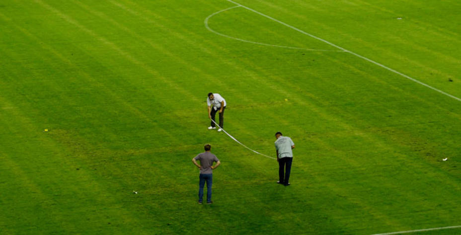Los jardineros del estadio trataron de borrar la esvástica durante el descanso. Reuters.