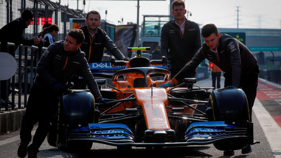 Varios mecánicos de McLaren empujan el monoplaza de Lando Norris en el Circuito de Shanghai. EFE