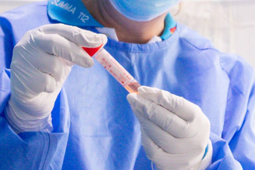 Un trabajador sanitario protegido sostiene una de las probetas utilizadas para la realización de tests PCR en