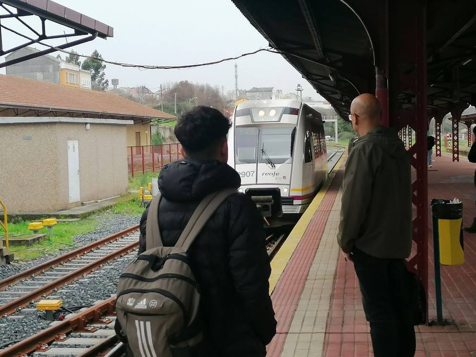 Unos viajeros esperando la llegada de un tren de FEVE en la estación de Ferrol