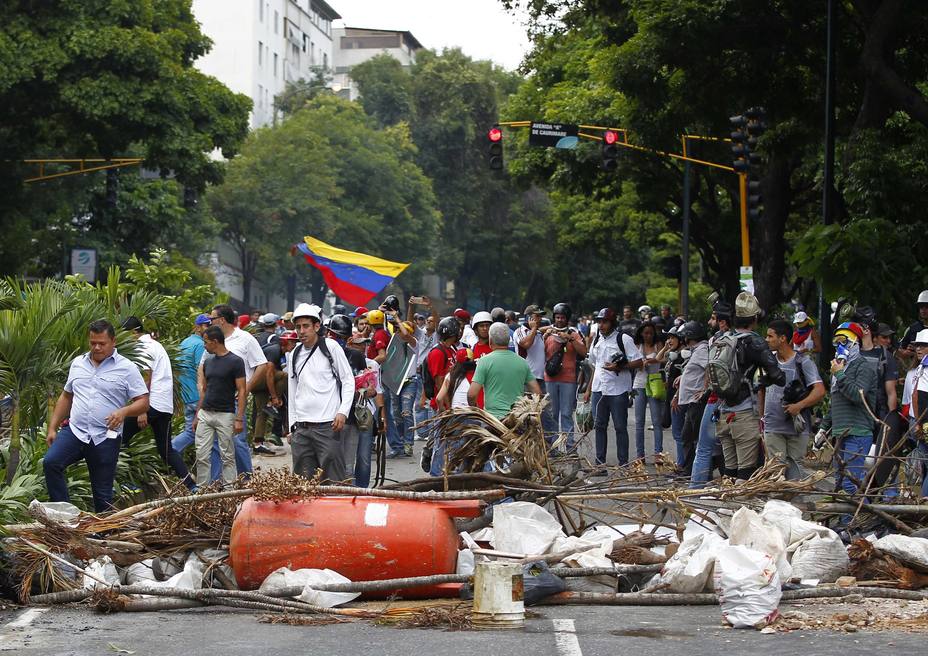 Opposition supporters stand near a barricade as clashes break out while the Constituent Assembly election is being carried out in Caracas