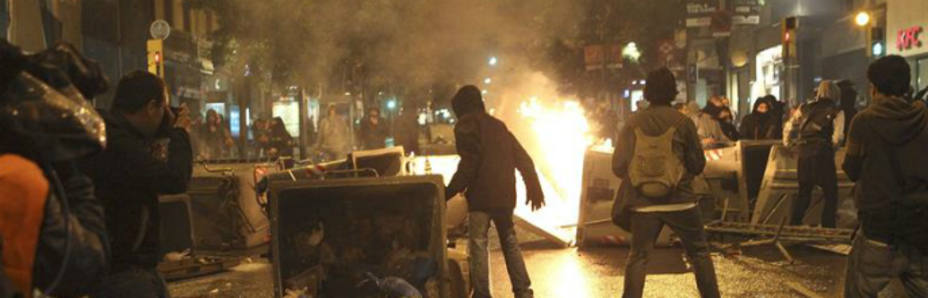 Manifestantes volcando contenedores en las calles de la ciudad condal (EFE)