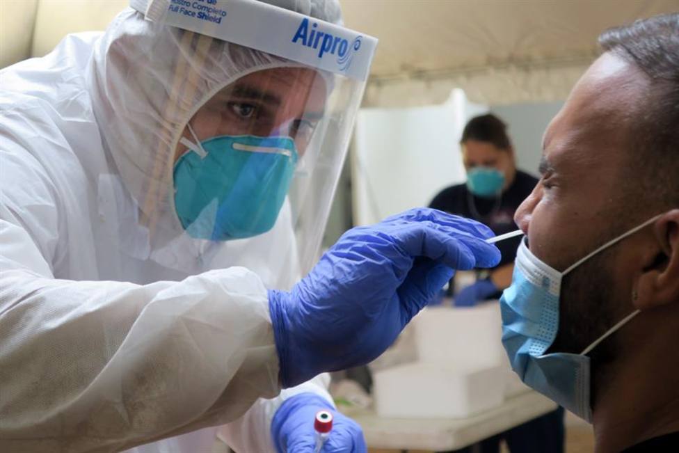 Un técnico de laboratorio inserta un hisopo en la nariz de un residente para la prueba del coronavirus