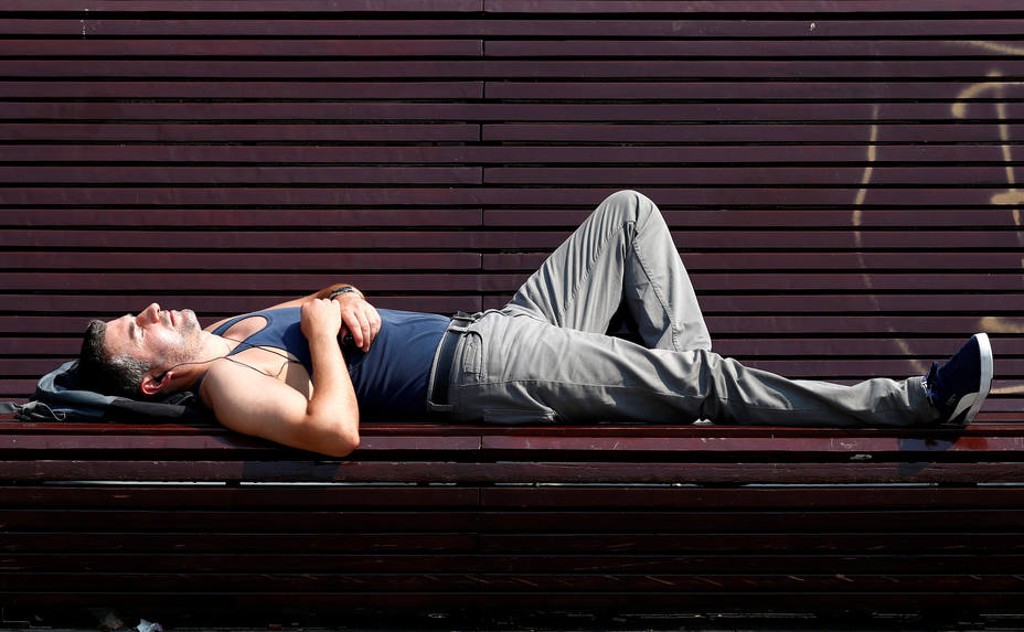 A man sunbathes on a bench on a hot summer day in Brussels