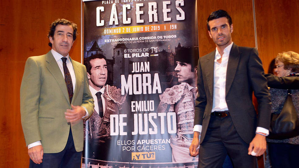 Juan Mora y Emilio de Justo junto al cartel anunciador de su mano a mano en Cáceres