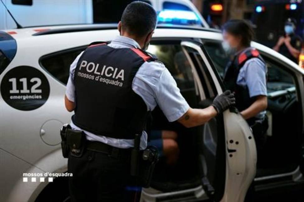 Mossos dEsquadra llevando a cabo una detención en su coche patrulla