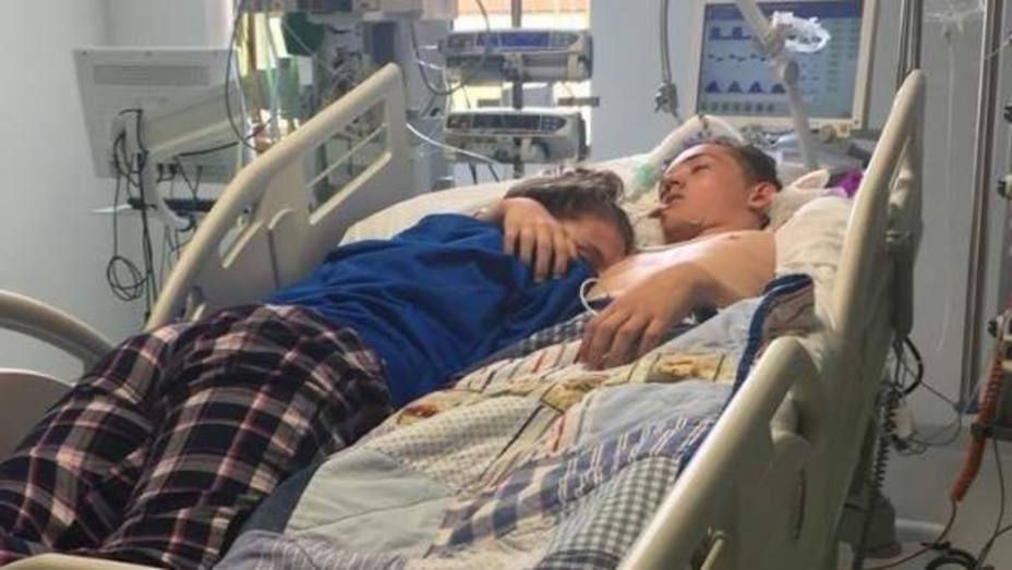 una chica que duerme junto a su novio en el hospital