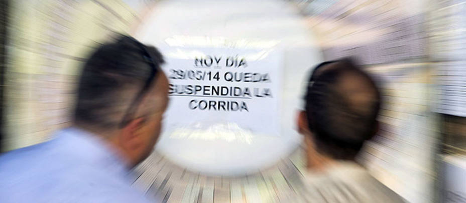 Dos aficionados observan el cartel que anunciaba la suspensión en Córdoba. EFE
