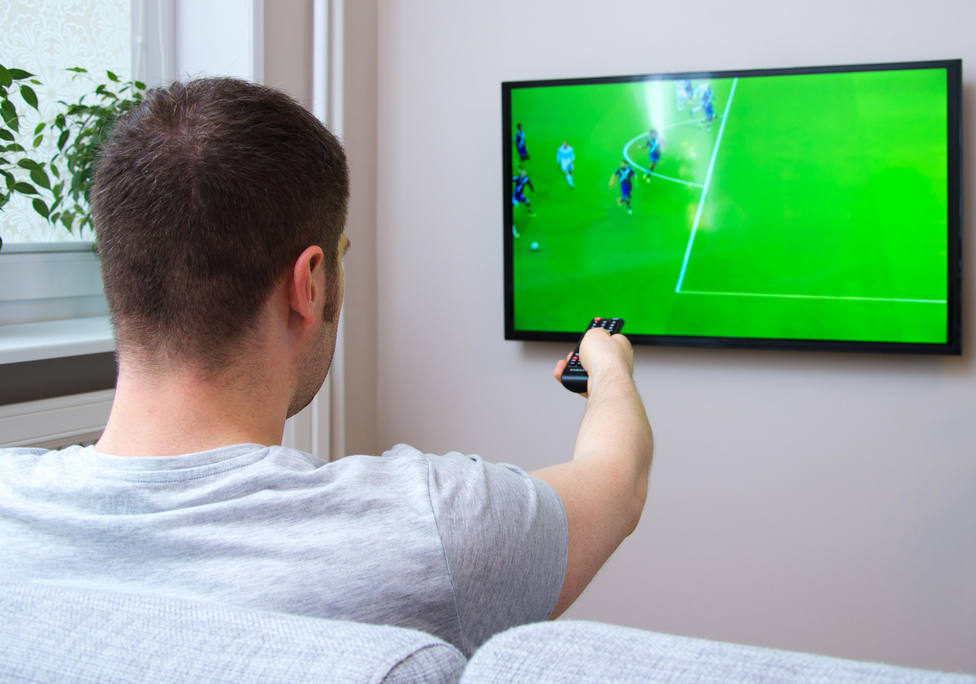 Hombre viendo el fútbol en televisión