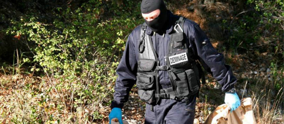 Un gendarme francés con armas de ETA halladas en un zulo.