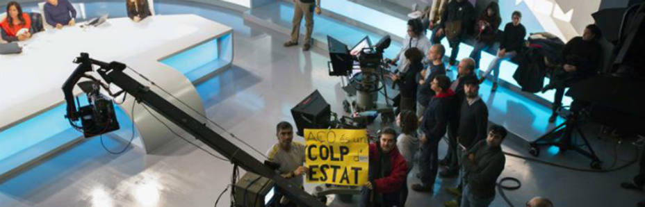 Trabajadores de RTVV muestran un cartel en protesta por el cierre de Canal 9 en el plató de informativos (EFE)