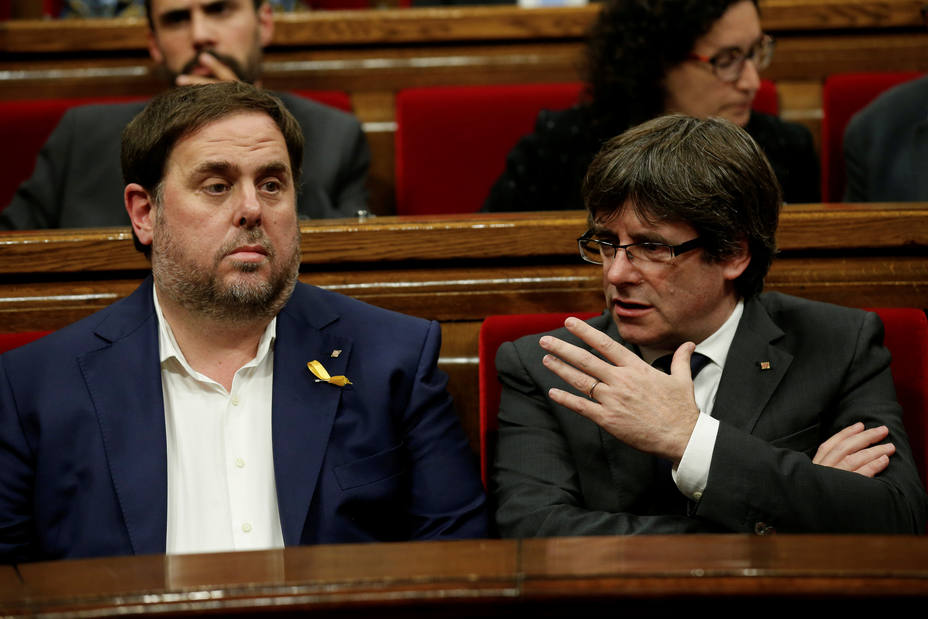 FILE PHOTO: Catalan President Puigdemont talks to Catalan Vice President Junqueras at the start of a session at the Catalan regional Parliament in Barcelona