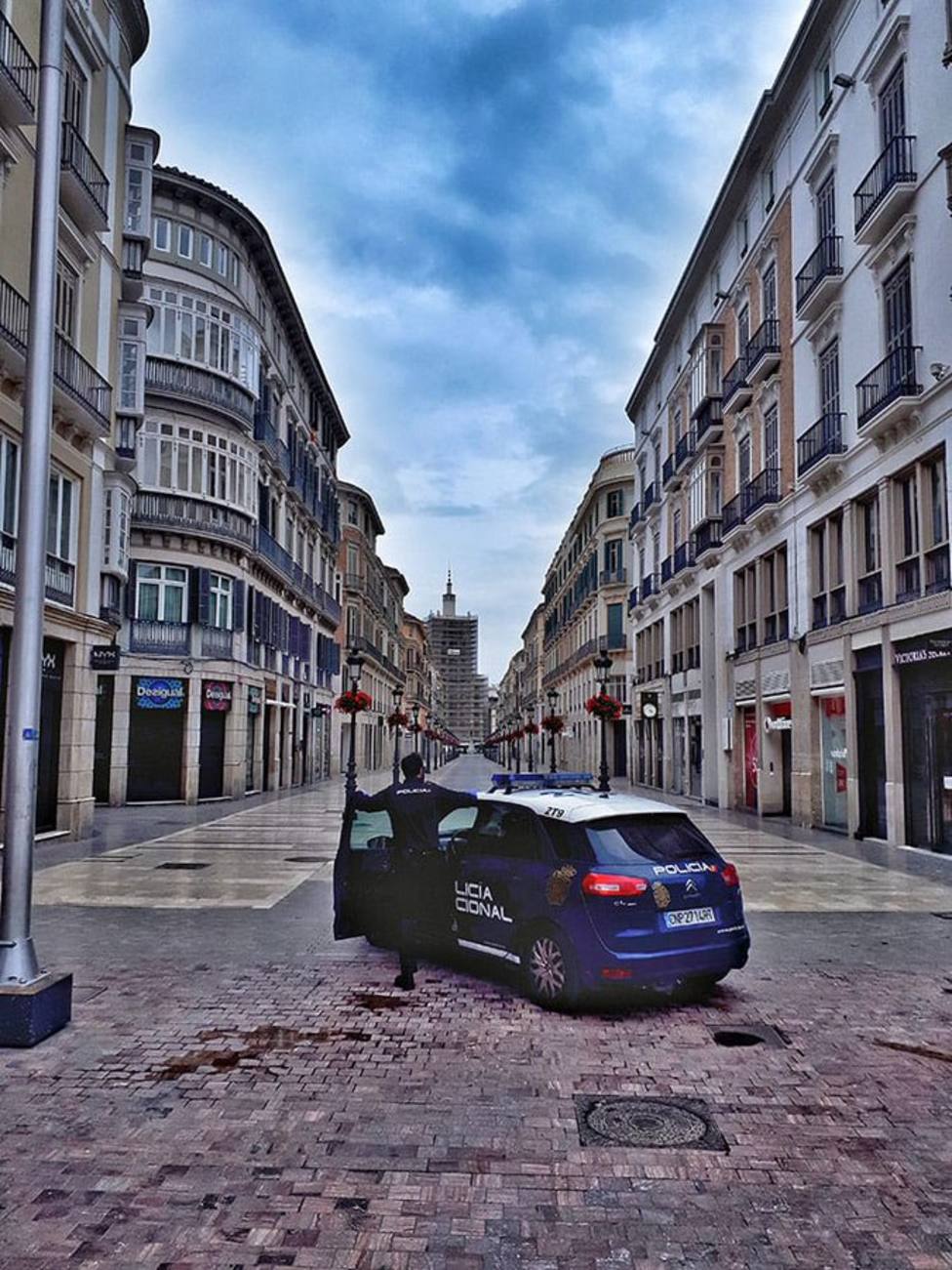 Imagen de la patrulla policial con la Calle Larios de fondo, vacía.