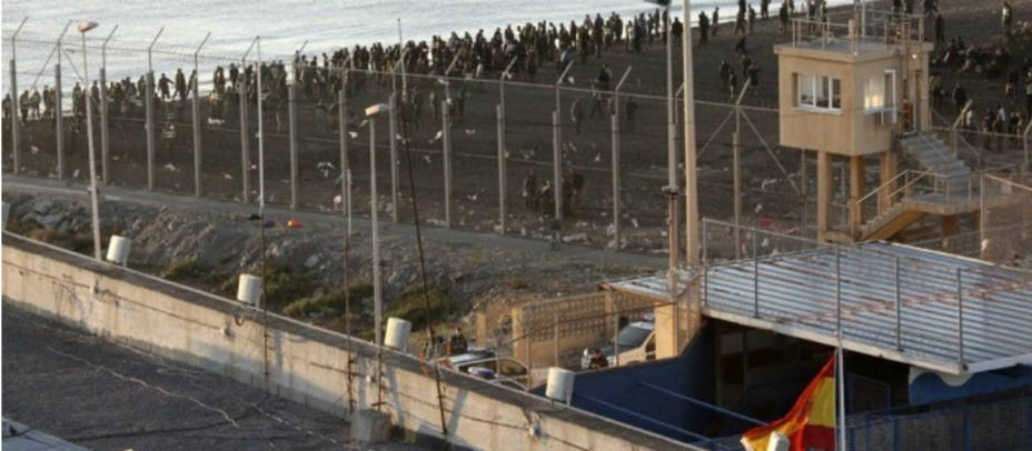 Inmigrantes en la frontera de Ceuta. Un grupo de inmigrantes en territorio marroquí, junto a la valla fronteriza de separación en Ceuta. EFE